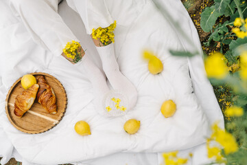 Enjoying a relaxing picnic with croissants and lemons in a vibrant garden