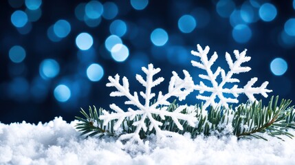 Festive snowflakes on snowy fir branch, blue bokeh background, winter holiday card