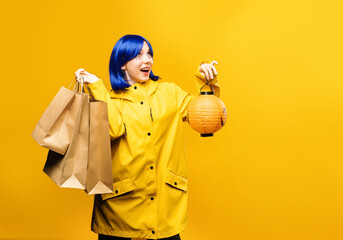 Halloween sales. Young girl wearing yellow jacket with shopping bags and halloween jack o lantern...