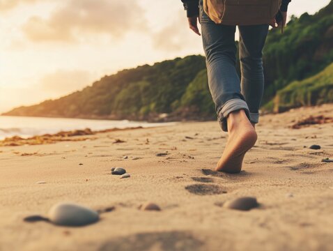 Back view of a man strolling near the shoreline, jeans rolled up and a backpack. The golden hour light warms the sand and sea, while trees and hills frame the coastal landscape in soft tranquility - Powered by Adobe