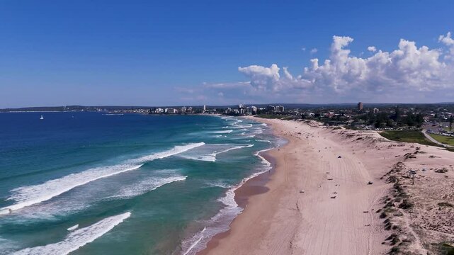 Sydney, NSW, Australia - UHD Video - High aerial view from Wanda Beach to Cronulla on a beautiful sunny day in May 2024 with calm waves and a blue sky.
