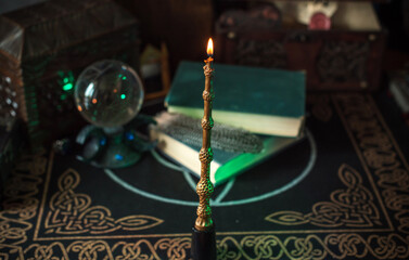 Magical books on a table, magic candle wand, concept of fairy tales