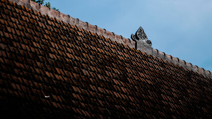 Traditional Clay Roof Tiles with Artistic Accents under Blue Sky