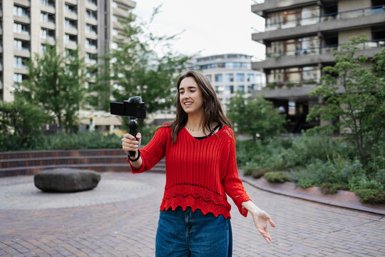 Woman vlogging with gimbal in urban setting