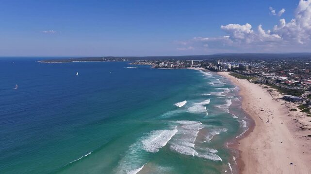 Sydney, Australia - UHD Video- 360 degrees drone flyover view from Wanda Beach to Cronulla on a beautiful day in May 2024 with calm waves and a beautiful blue sky.
