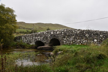 Historic stone bridge over a stream near Tongue village, Sutherland, Highlands of Scotland. Typical...
