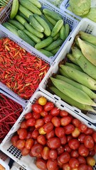 Various kinds of colorful fresh vegetables in plastic boxes sell at traditional market.
