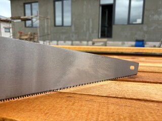 Close-up of saw teeth on wood background. Carpentry tool for cutting boards by hand.