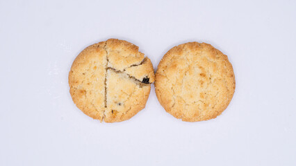 Two Golden Cookies with Dark Specks on White