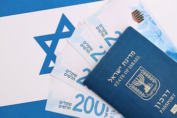 Israel New Shekels banknotes and passport on flag. The current Israel money bills and pass