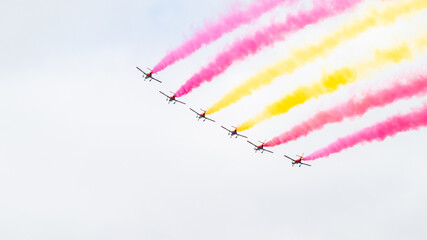 Aerobatic patrol performing at an air show in Spain, drawing the Spanish flag