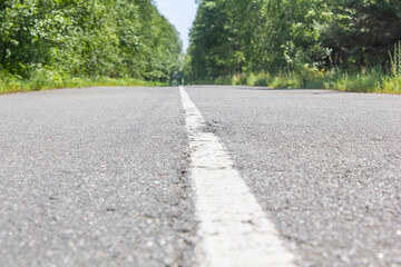 asphalt road without cars in the middle of forest and field