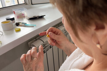 Senior woman hands holding bottle of cuticle oil