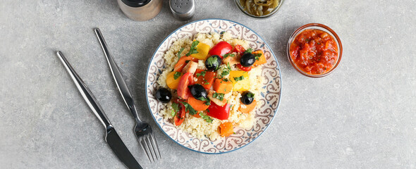 Plate with couscous and vegetables on grunge background
