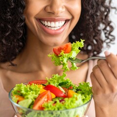 Close-up of a woman enjoying a colorful salad, with focus on her smiling mouth and forkful of fresh vegetables. A vibrant and healthy eating concept perfect for lifestyle, wellness, or nutrition theme