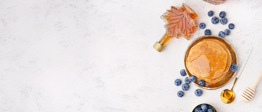 Tasty pancakes with blueberries and maple syrup on white background - Powered by Adobe