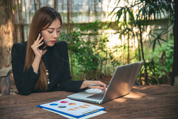 Happiness Asian Woman working from home using laptop online meeting in home office. Happy relax...