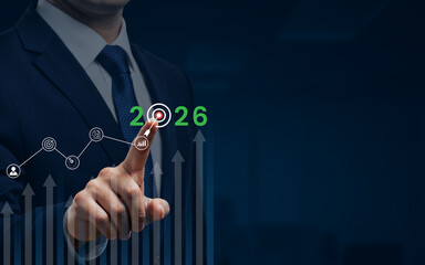 Businessman pointing at the year 2026 with a target and growth graph