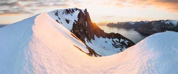 Scenery of blue waters and green mountains with remnants of snow in spring under clear skies on the island of Senja, Senja municipality, Troms county, Mefjorden,  Norway, Europe. Tourist area