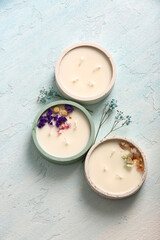 Holders with candles and flowers on blue background