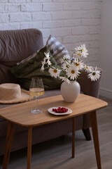 A Cozy Living Room Setup Featuring Beautiful Flowers and Refreshments for Comfort