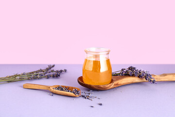 Jar of sweet lavender honey and flowers on lilac table