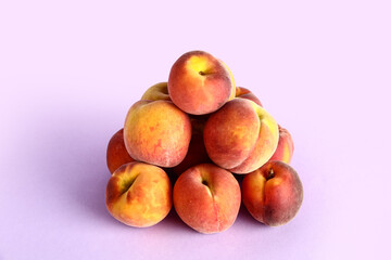 Heap of sweet peaches on lilac background