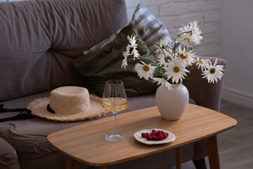 A Cozy Living Room Setup Featuring Beautiful Flowers and Refreshments for Comfort