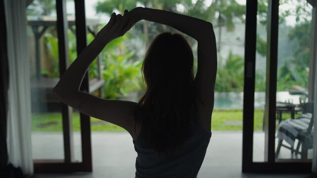 beautiful red-haire gitl doing stretching in the morning witho green jungle background on Bali