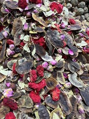 Herbal tea blend with leaves and pomegranate flowers and different dry flowers. Natural loose-leaf infusion with floral aroma and health benefits