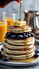 Vertical banner, wallpaper for social media of stacked ricotta pancakes, with glistening blueberries a tab of warm butter melted on top and beginning to melt down the sides of the stack