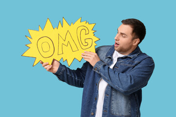 Shocked young man with text OMG on blue background