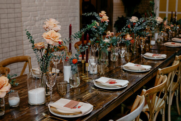 Elegant wedding table setting with floral centerpieces and candles on wooden table