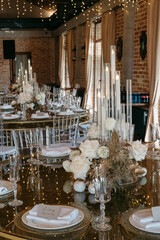 Elegant indoor wedding table setting with candles flowers and crystal glassware in a romantic atmosphere