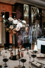 Elegant floral centerpiece in luxurious banquet setting with candle decor
