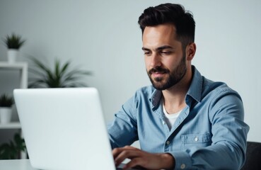 A man working on a laptop in a modern, minimalistic office environment
