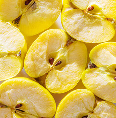 Broken yellow apple halves displayed in a bright arrangement showcasing texture and seeds....