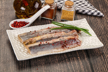 Salted marinated herring fillet with spices