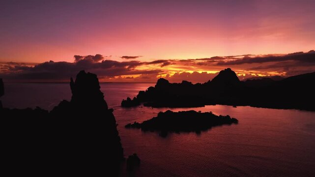 Aerial view of serene coastline with dramatic rock formations at sunset, New Caledonia.
