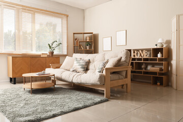 Interior of stylish living room with beige couch, wooden commode and shelf units