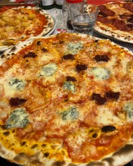 Traditional Italian pizza with gorgonzola cheese and spicy sausage, crispy thin crust, served at...