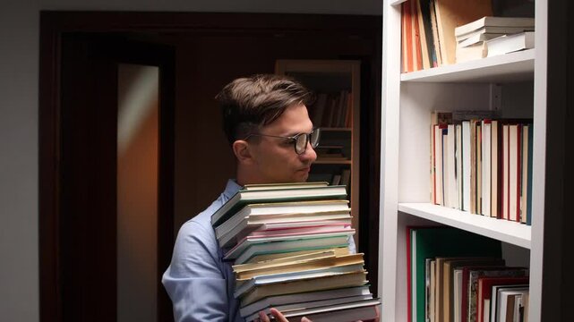 Librarian carrying stack of books in library