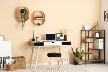 Interior of modern office with workplace, shelf unit and plants