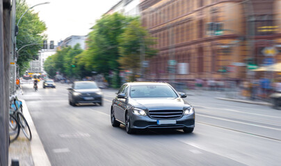 Modern sedan on city street. Car in motion. Urban traffic flow