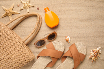 Summer composition with flower, starfishes and beach accessories on sand as background, closeup