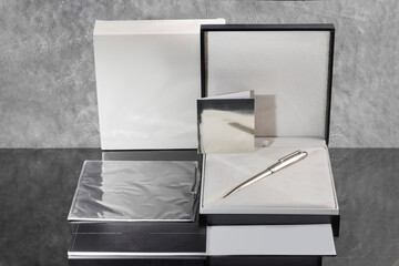 Branded pen with cufflinks and business card holder in a box. Gift set. Office interior.