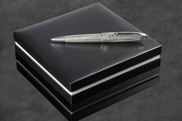 Branded pen with cufflinks and business card holder in a box. Gift set. Office interior.