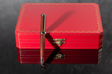 Branded pen with cufflinks and business card holder in a box. Gift set. Office interior.