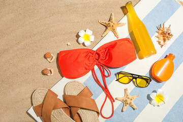 Composition with bottle of sunscreen cream, starfishes and beach accessories on sand as background