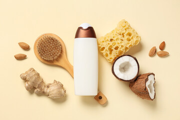 Composition with bottle of shower gel, bath sponge, ginger root and almonds on beige background